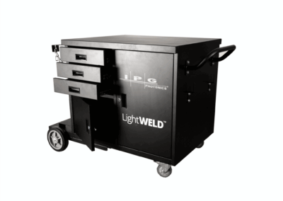 A cut-out shot of the black wheeled IPG LightWELD Welding Cart - Showing a handle for moving the cart around, as well as two cupboards, one with an open door and three drawers at various stages of being open.