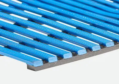 A close up of a blue safety mat with regular rectangular holes.