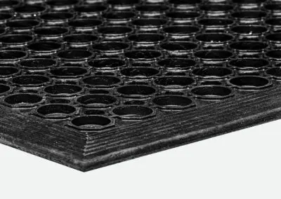 A close-up of a safety mat with regular circular holes in it