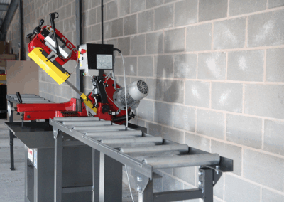 350mm Roller Track, paired with a Bianco Bandsaw in a workshop environment against a wall made up of cinder blocks.